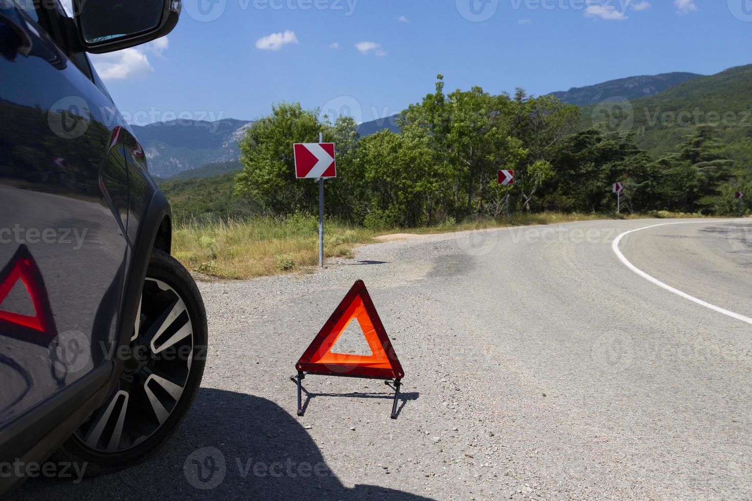 un segnale di arresto di emergenza di un veicolo è installato sulla strada, accanto all'auto. copia spazio. foto