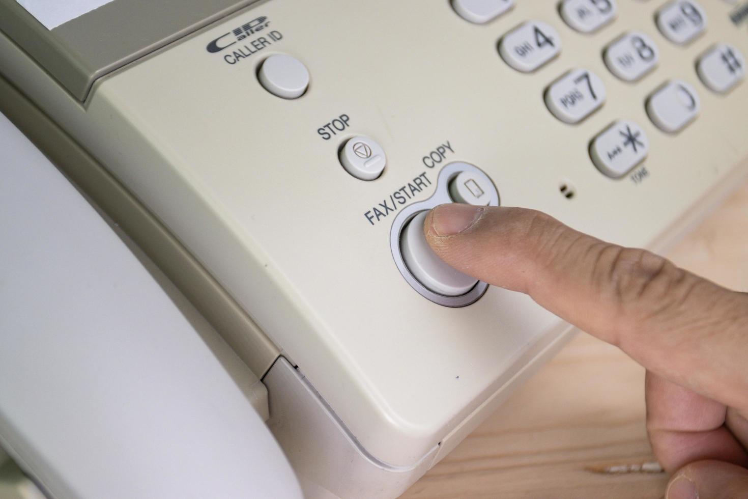 l'uomo della mano sta usando un fax nel concetto di business dell'ufficio foto