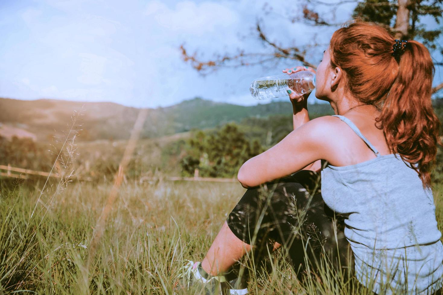 le donne si esercitano per strada. Parco Naturale. bevi acqua sana. donne asiatiche foto