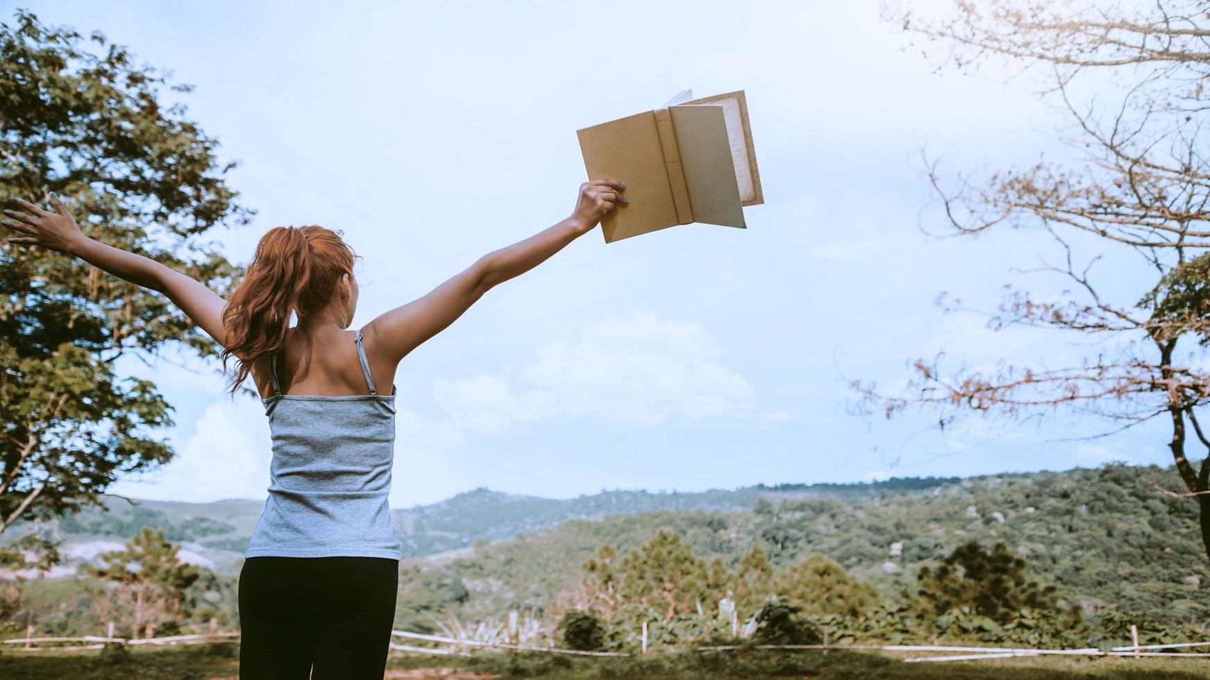 le donne si rilassano leggere un libro natura di montagna. clima felice e salubre foto