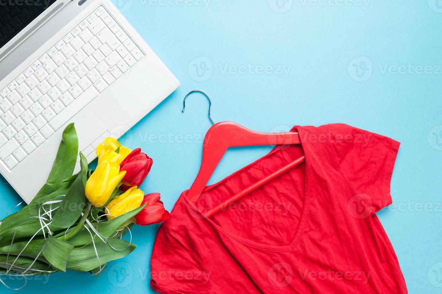 computer bianco e bouquet di tulipani con appendiabiti foto