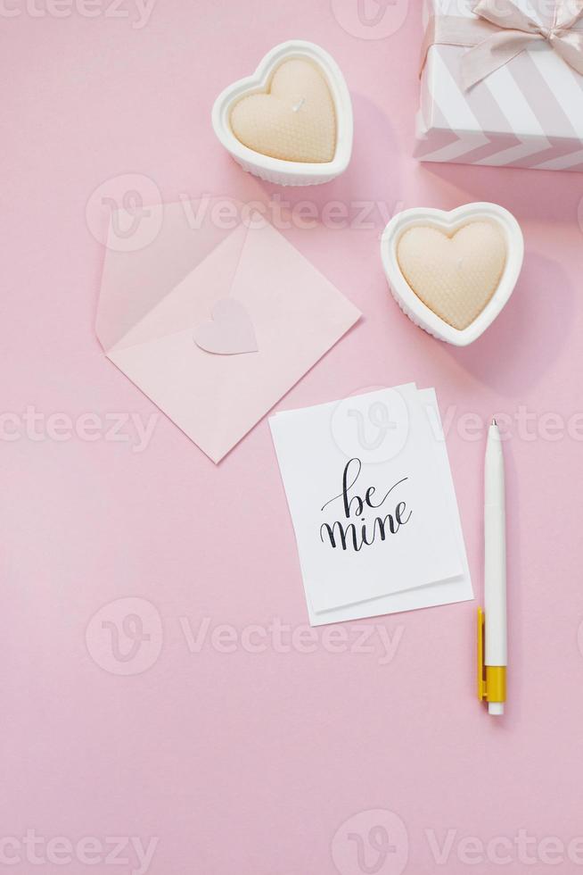 buona composizione di san valentino. mockup di biglietto di auguri vuoto, scatole regalo, cuori, coriandoli su sfondo rosa foto