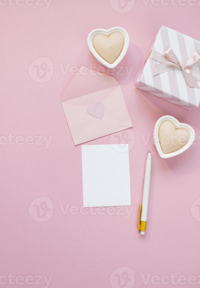 buona composizione di san valentino. mockup di biglietto di auguri vuoto, scatole regalo, cuori, coriandoli su sfondo rosa foto