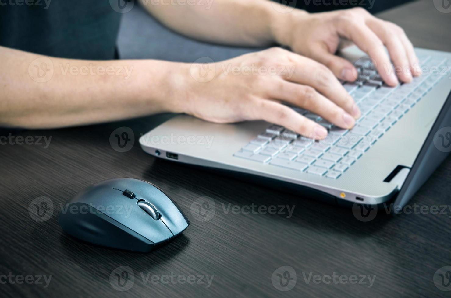 uomo che per mezzo del computer portatile con la tastiera bianca. lavorare in ufficio foto