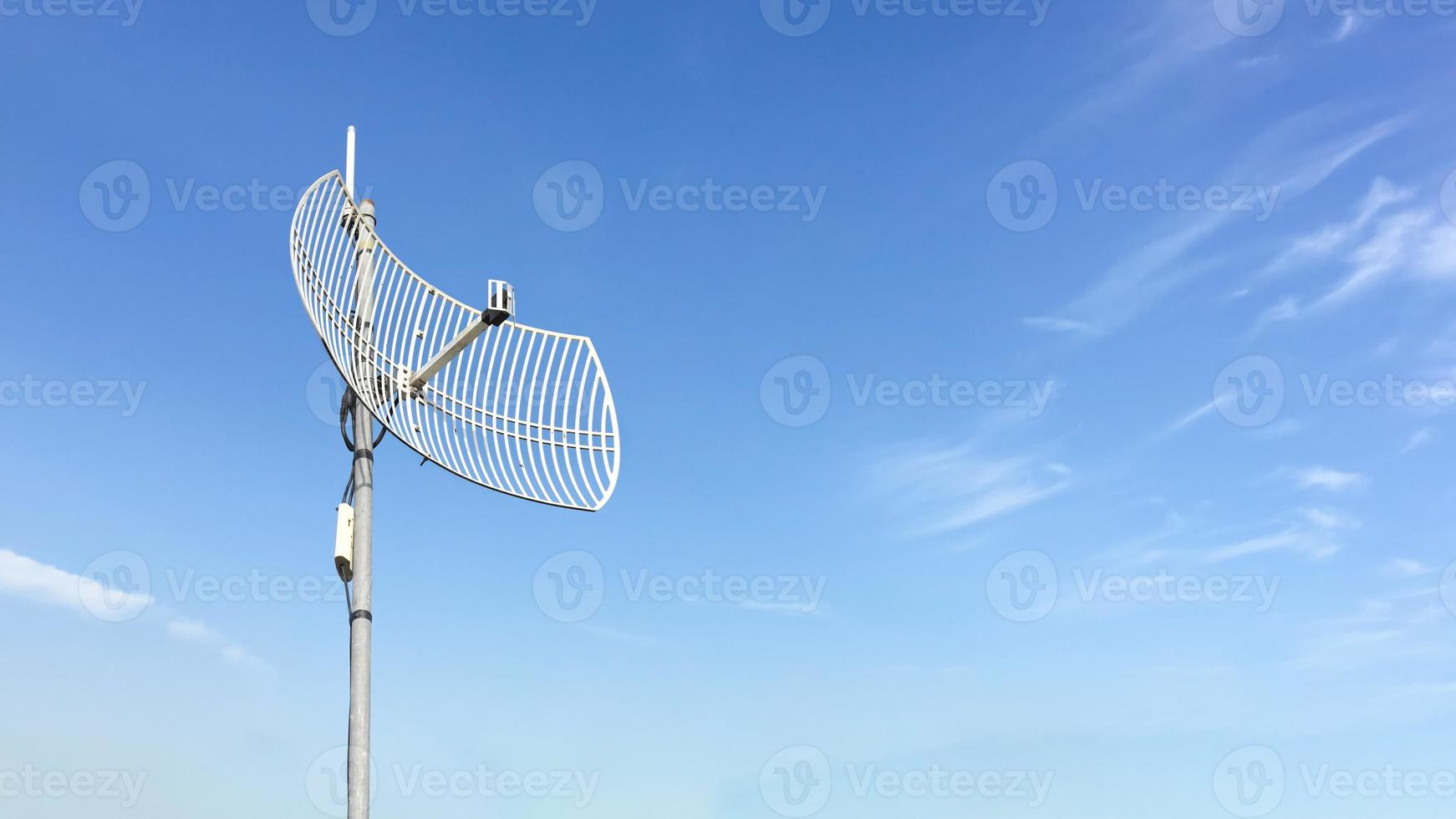 ricevitore internet wifi esterno e antenna ripetitore sul tetto dell'edificio con sfondo blu chiaro. foto
