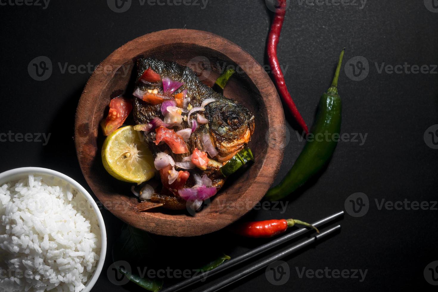 menu di pesce fritto piccante con ciotola di riso su sfondo nero. fotografia di cibo asiatico. buono per il menu del ristorante e il poster foto