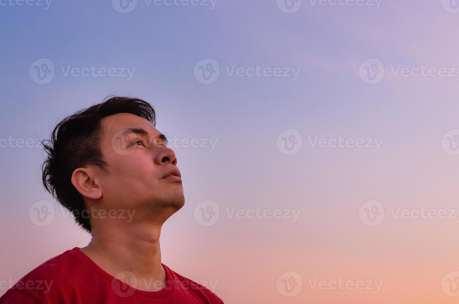 uomo asiatico alzando lo sguardo al cielo. espressione del viso di emozione. foto