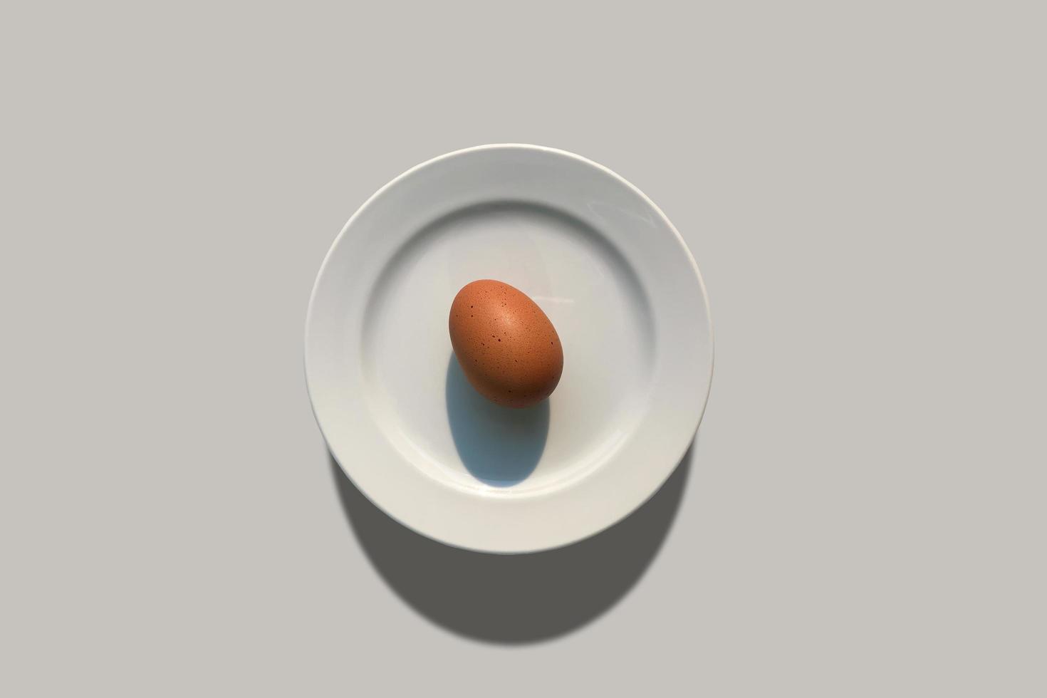 l'uovo mette sul piatto bianco. foto