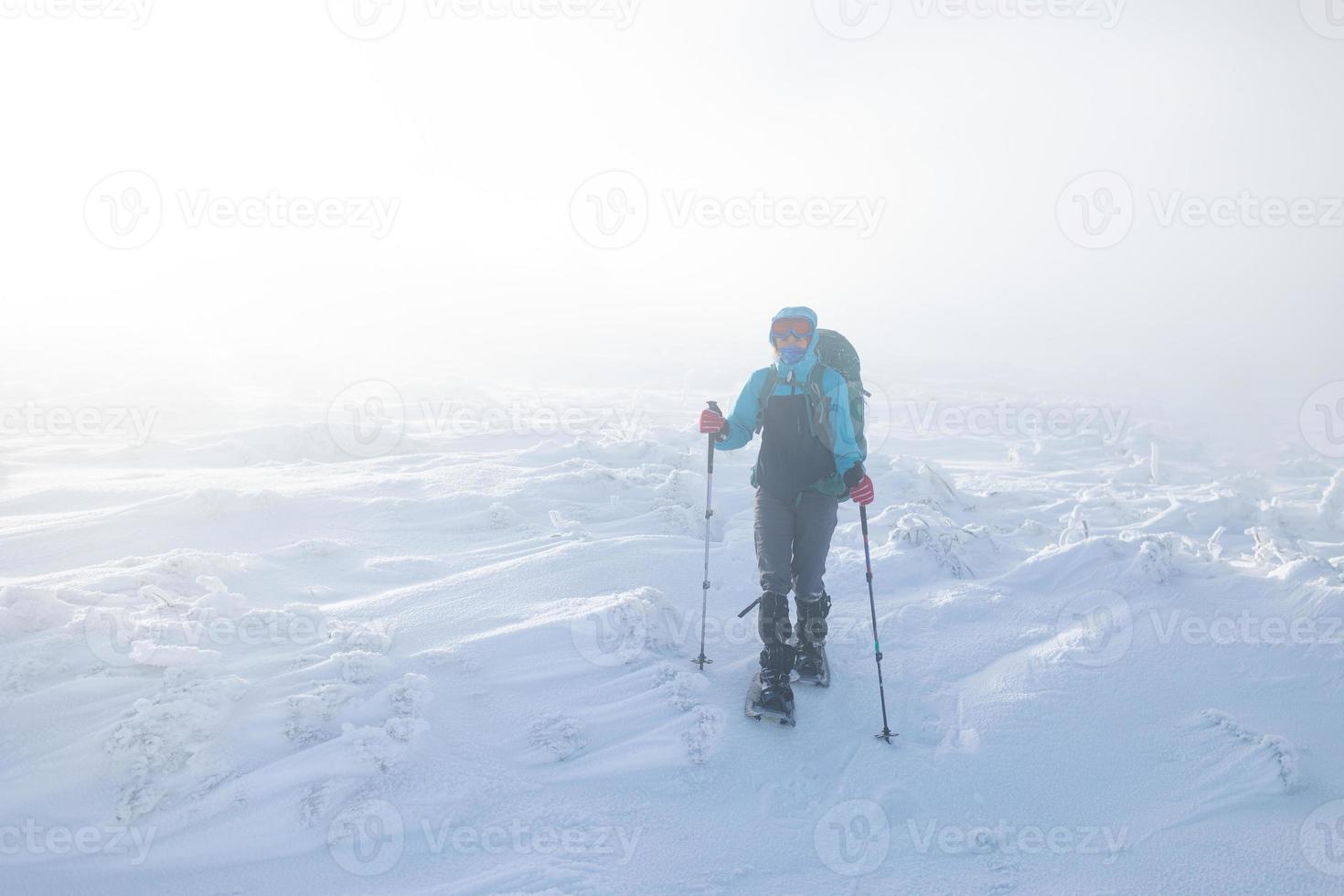 una donna in inverno che fa trekking nella nebbia foto