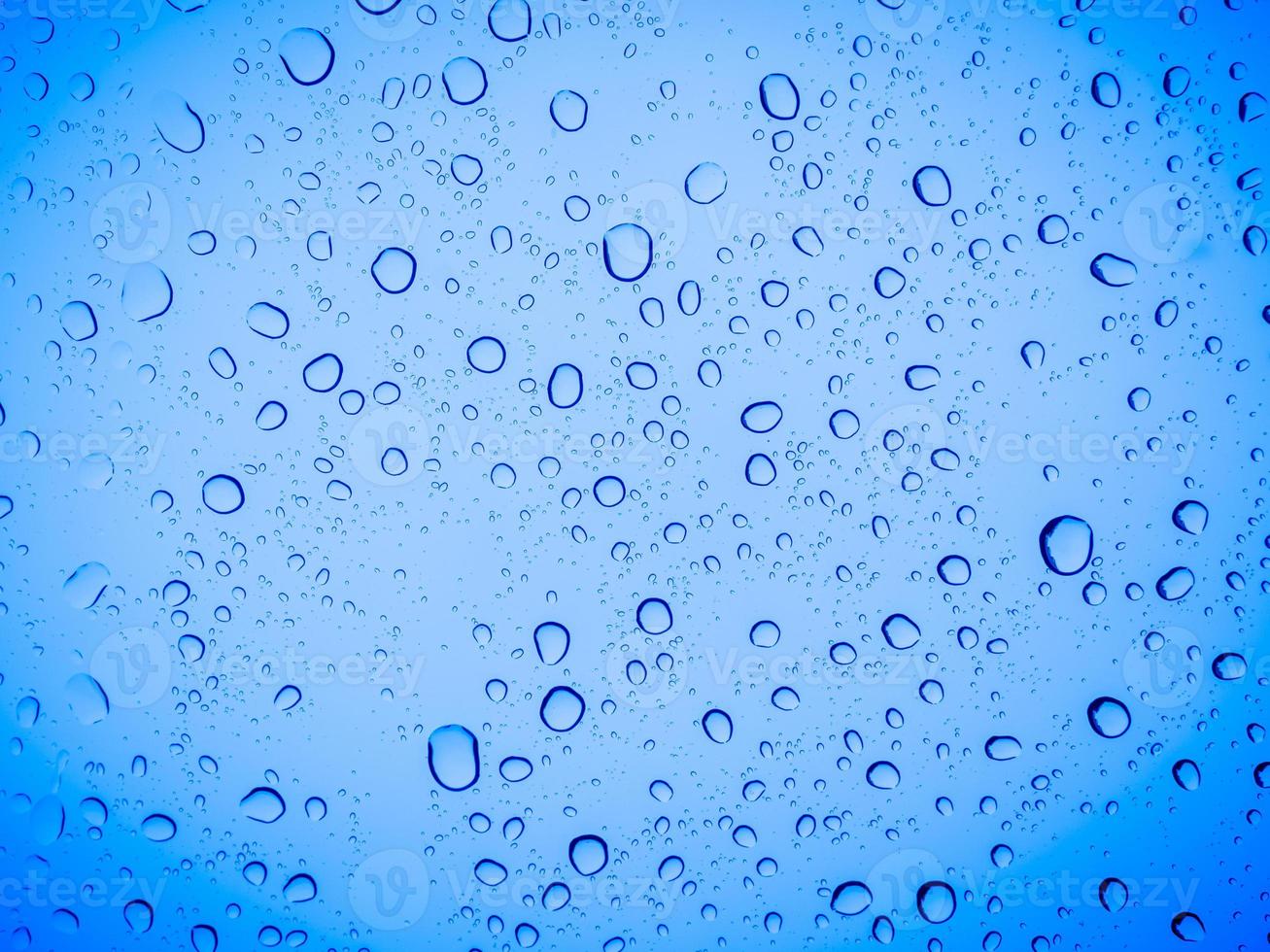 gocce di pioggia su un vetro blu, sfondo blu astratto. foto