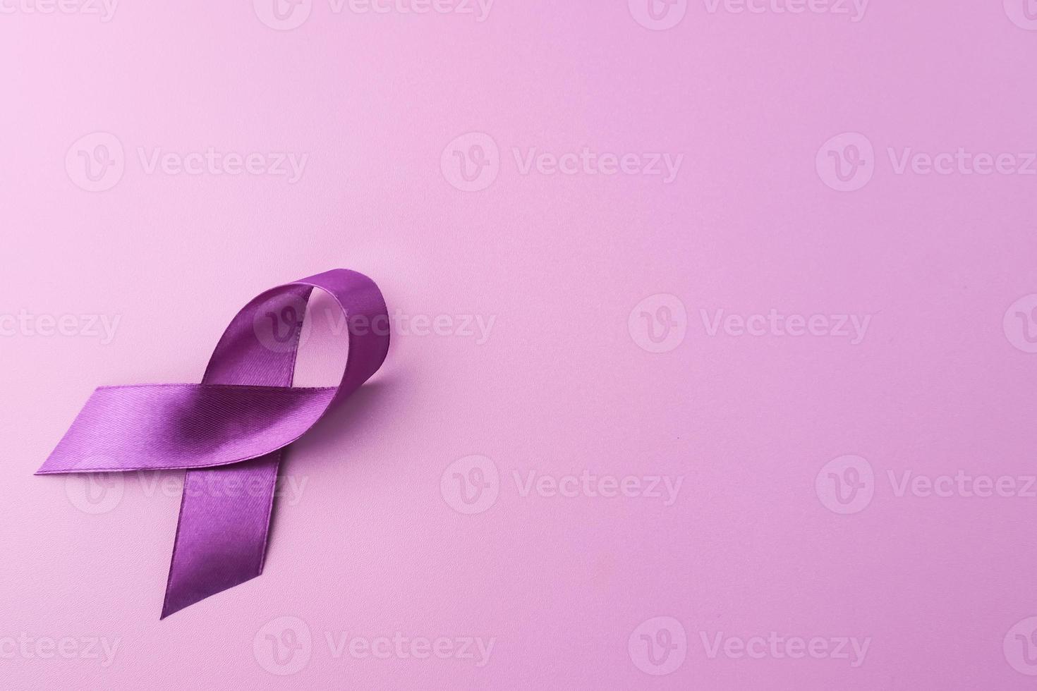 nastro viola come simbolo della giornata mondiale del cancro su sfondo di colore viola, spazio di copia. foto