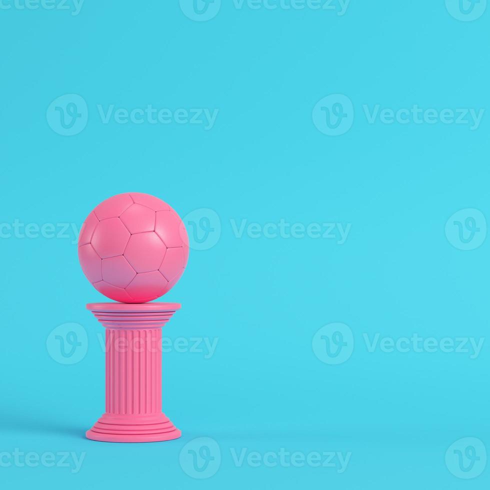 colonna rosa con pallone da calcio su sfondo blu brillante in colori pastello foto