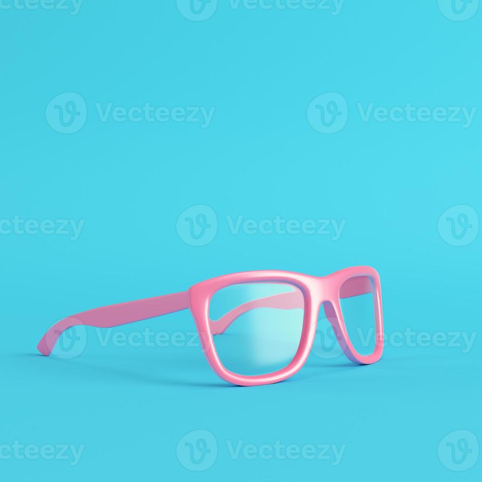 occhiali con lenti trasparenti su fondo azzurro brillante in colori pastello foto