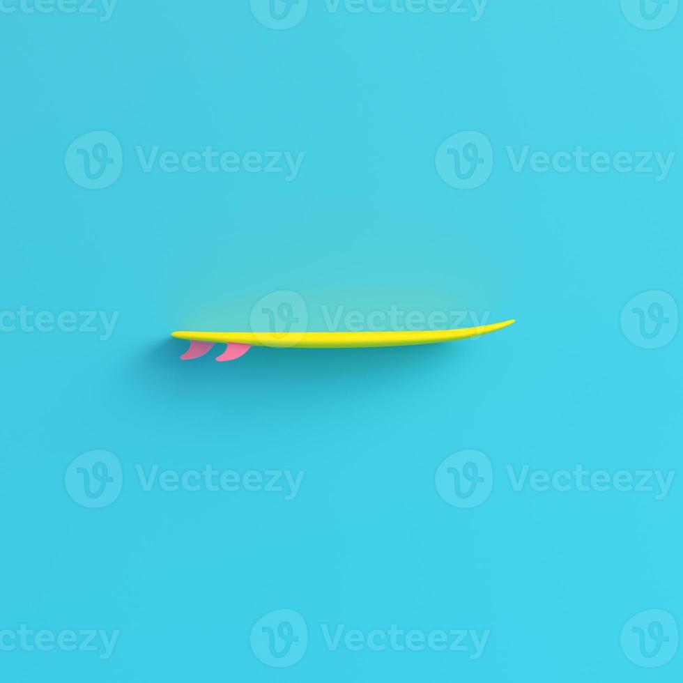 tavola da surf gialla su sfondo blu brillante in colori pastello foto