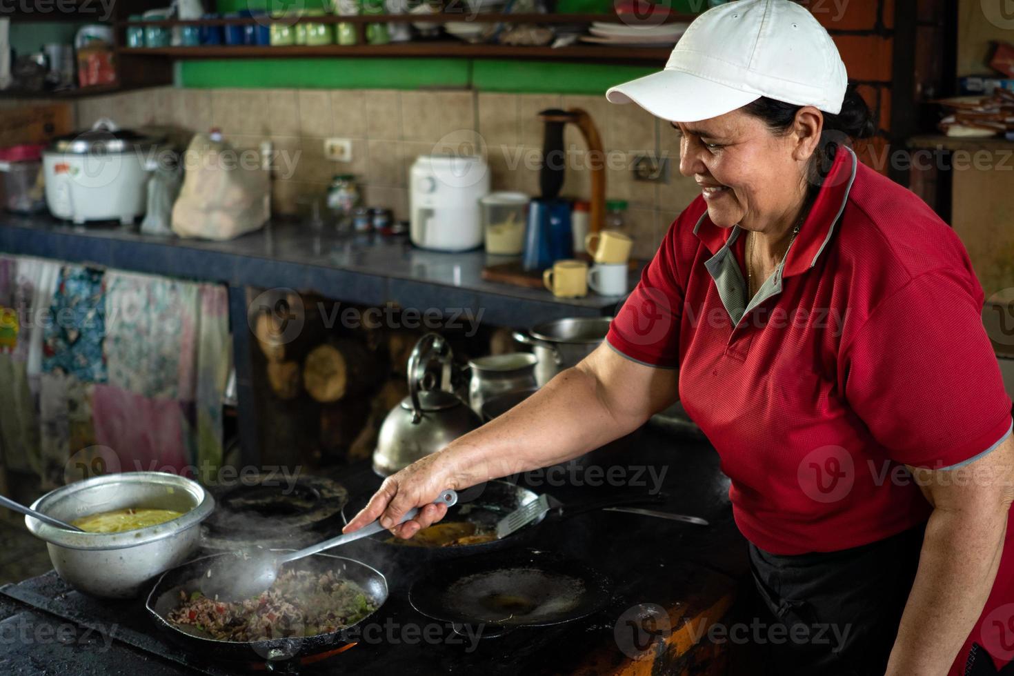 la donna sorride mentre cucina foto