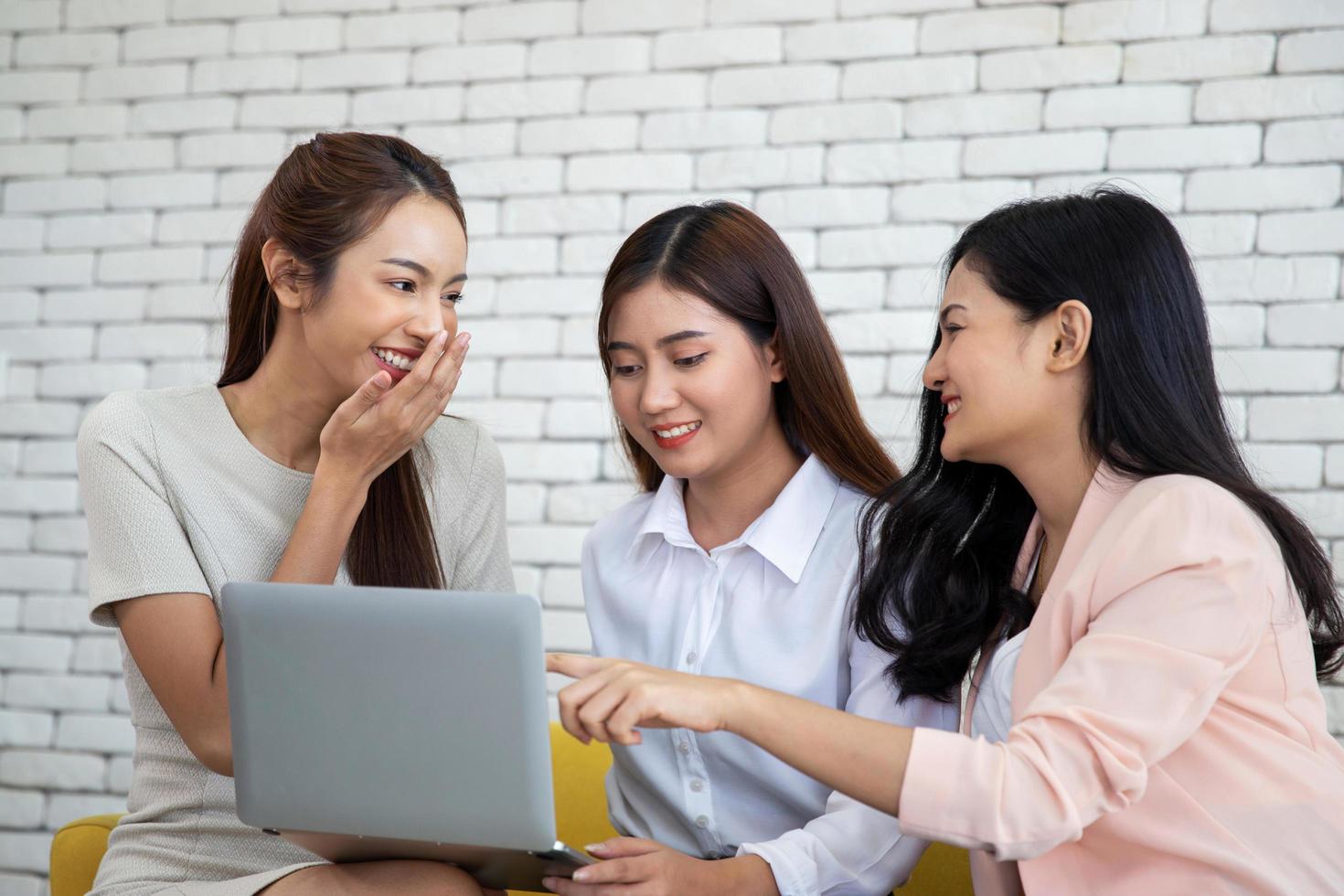 gruppo di donne d'affari di incontro e ridere allegramente mentre si diverte in ufficio foto