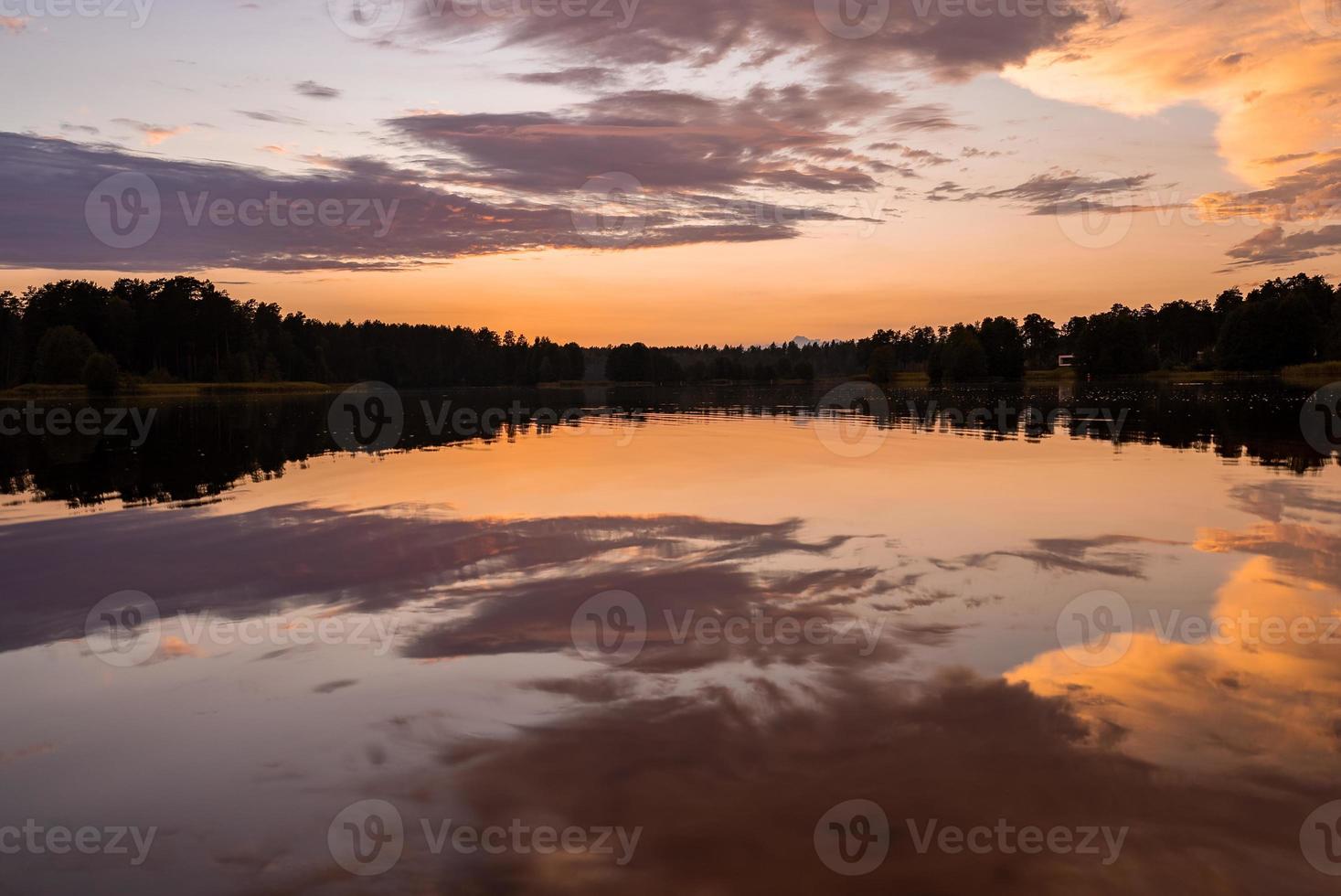 cielo colorato e acqua colorata nel lago riflessa nel tramonto serale. foto