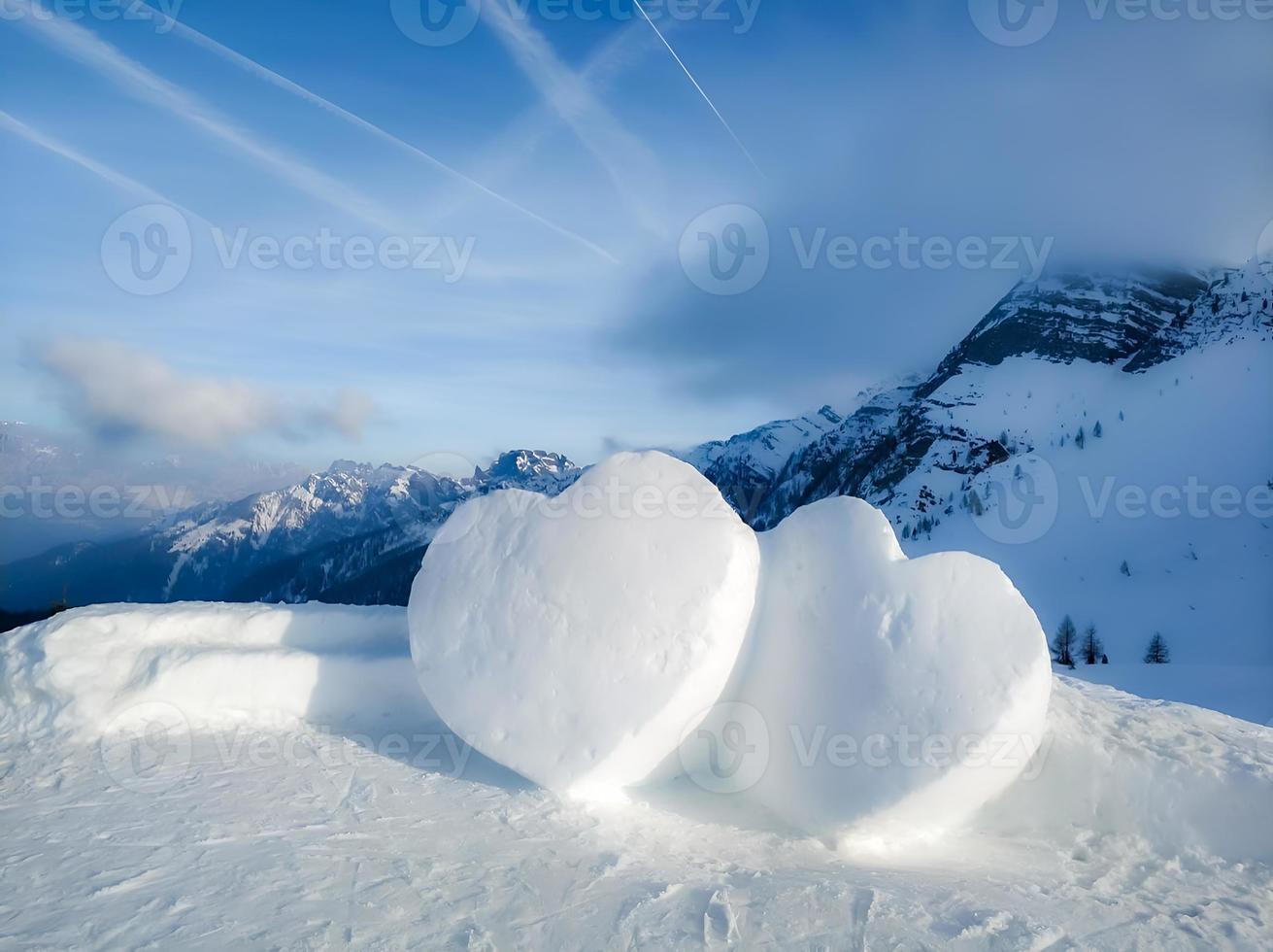 due grandi cuori di neve tra le bellissime montagne. foto