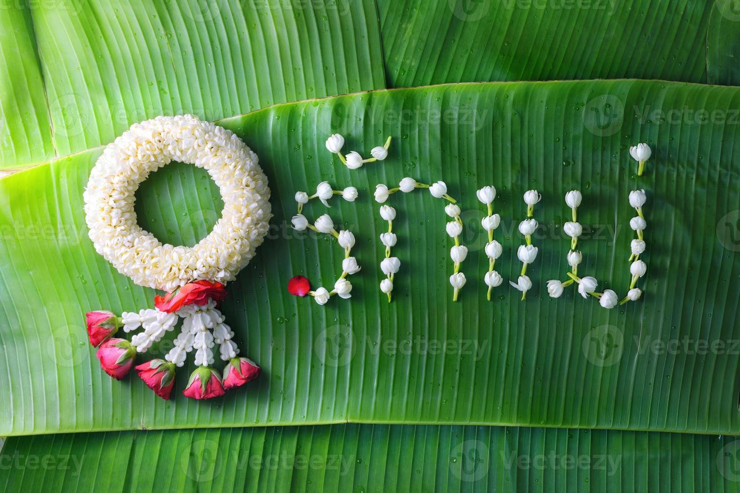 ghirlanda di gelsomino tradizionale tailandese. simbolo della festa della mamma in Thailandia su foglia di banana con amore madre in parola tailandese. foto