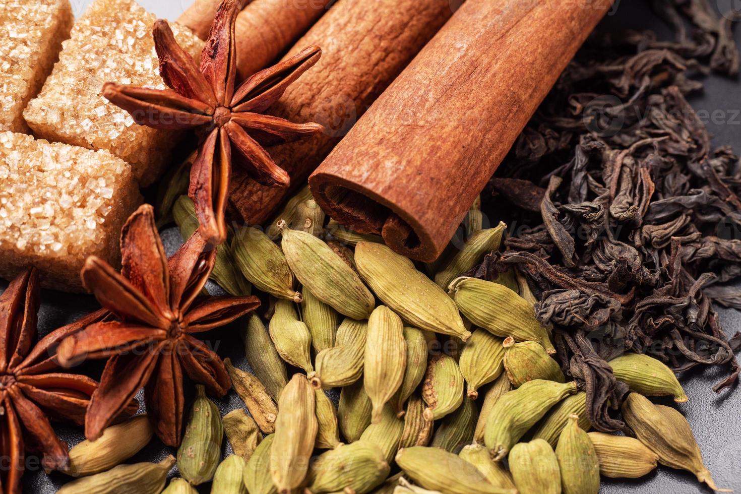 grani interi di cardamomo, un bastoncino di cannella anice stellato e zucchero di canna. copia spazio. ingredienti per preparare il tè masala della bevanda indiana. foto