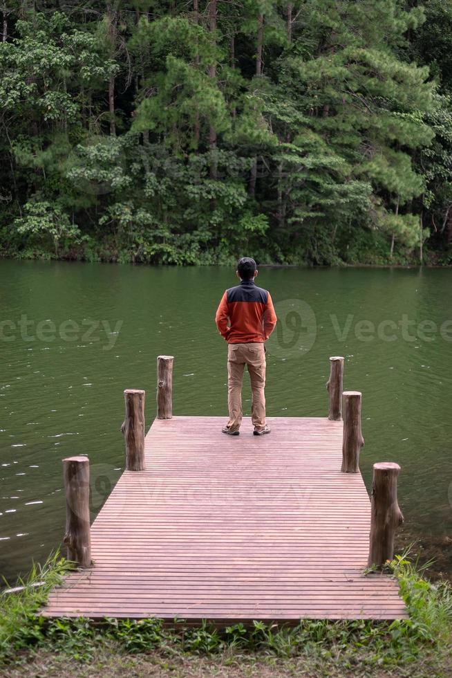 uomo viaggiatore felice in piedi e guardando la natura, turista solista in maglione che viaggia a pang oung, mae hong son, thailandia. concetto di viaggio, viaggio e vacanza foto