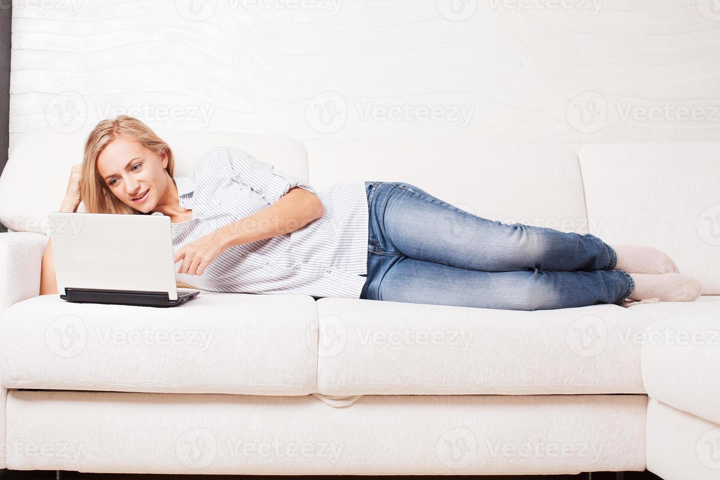 donna sul divano con il portatile foto
