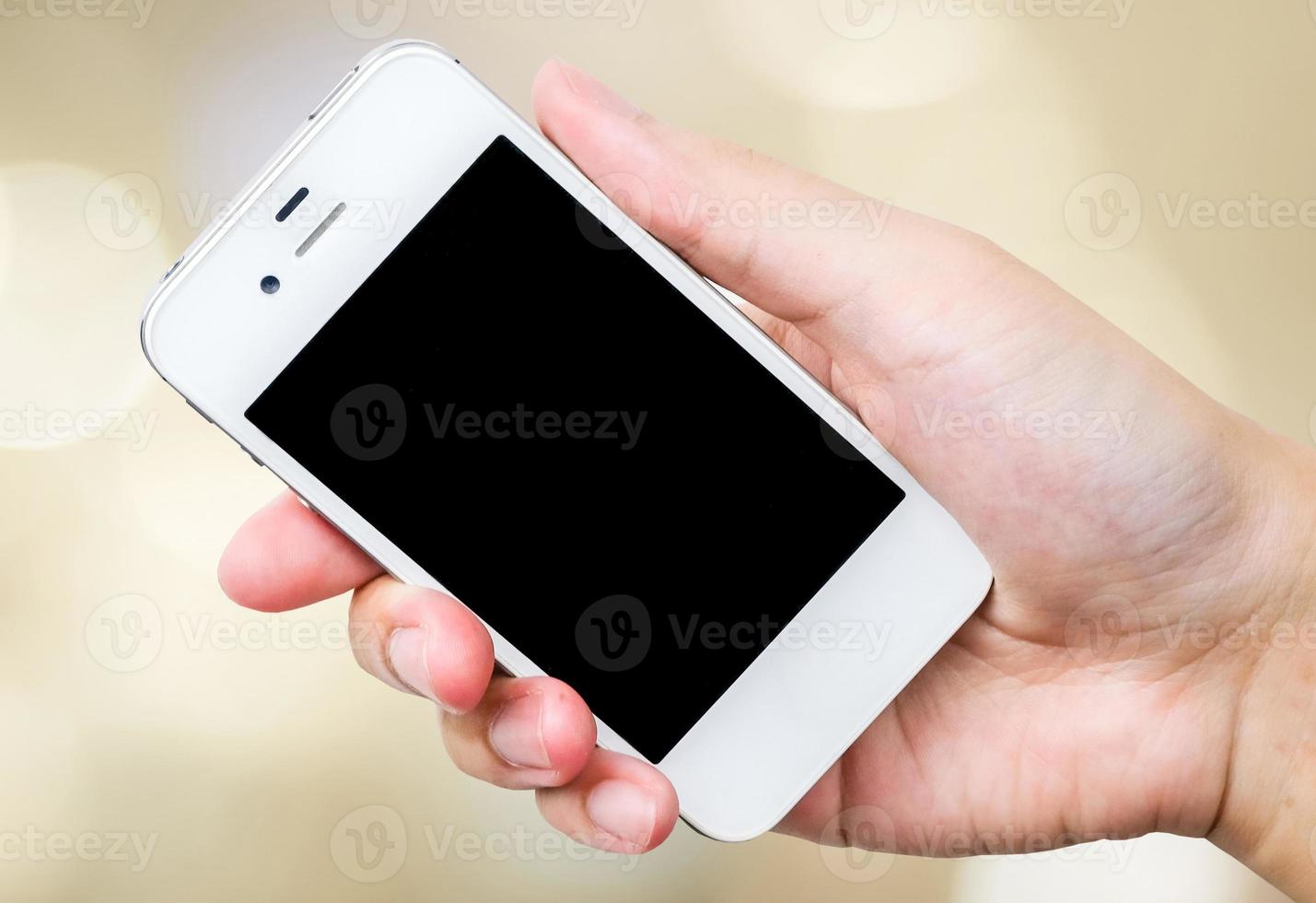 Smart Phone in mano su sfondo bokeh foto