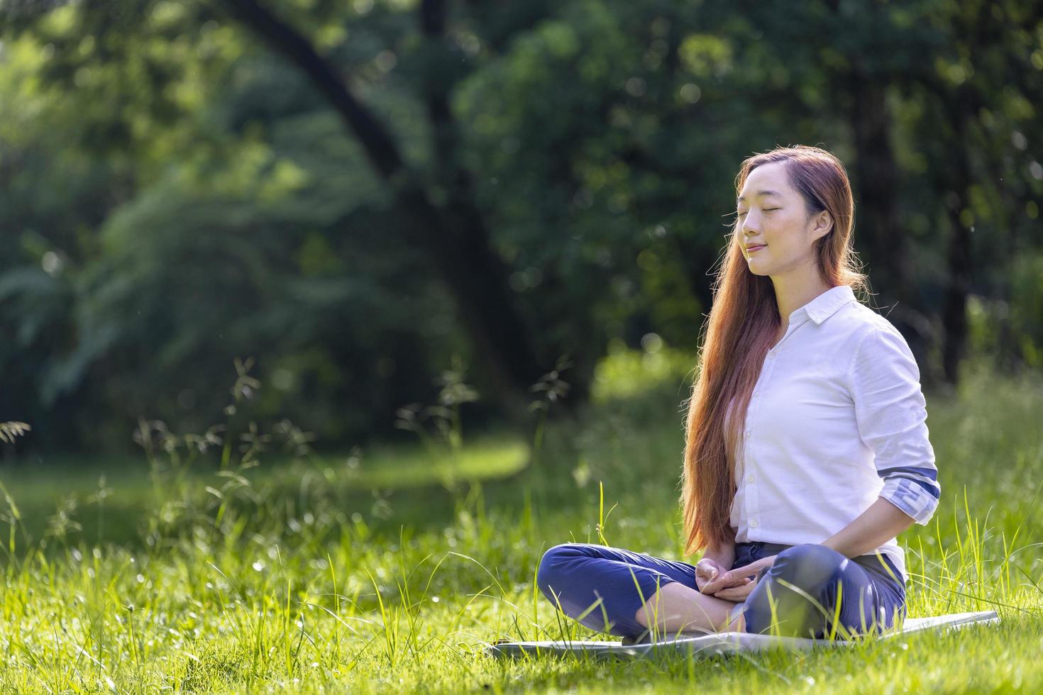 donna che pratica rilassante meditazione nella foresta per ottenere la felicità dalla pace interiore saggezza per mente e anima sane foto