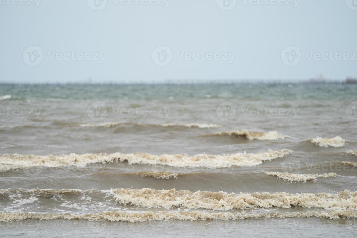 primo piano onda marrone sporca dal mare alla spiaggia. foto