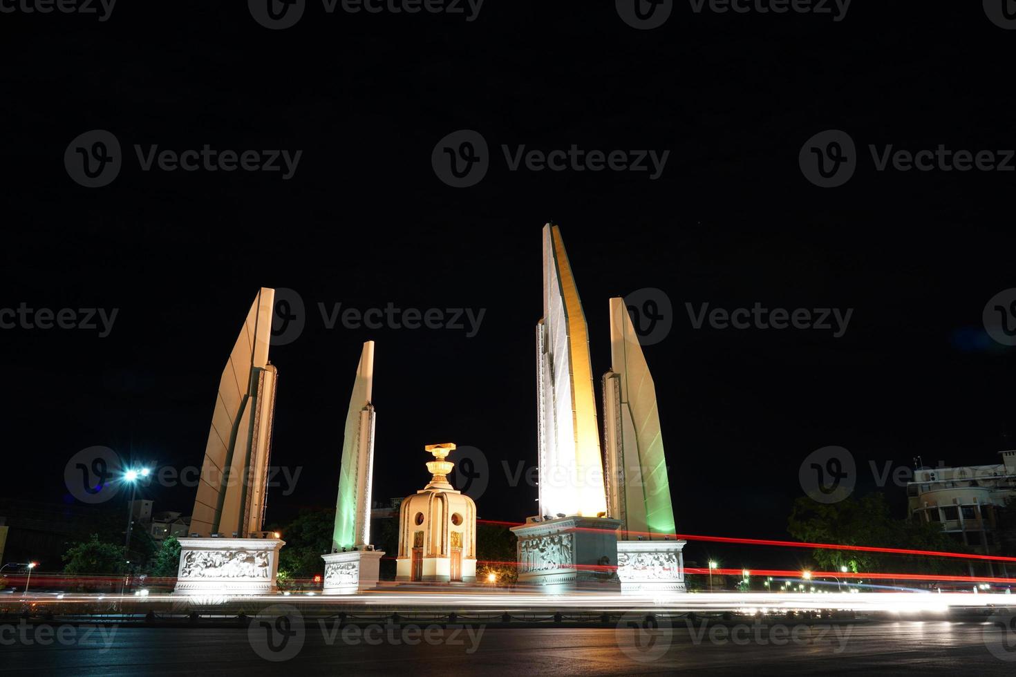 monumento alla democrazia della thailandia nella notte con la luce dell'auto in movimento sulla strada. foto