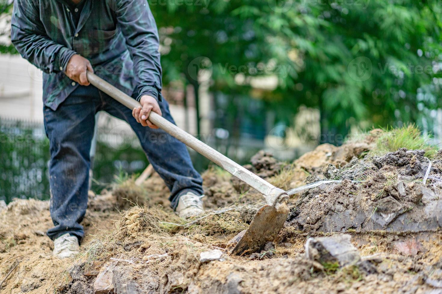 il giardiniere scava il terreno con la sua attrezzatura per il giardinaggio e prepara il terreno per la piantagione. foto