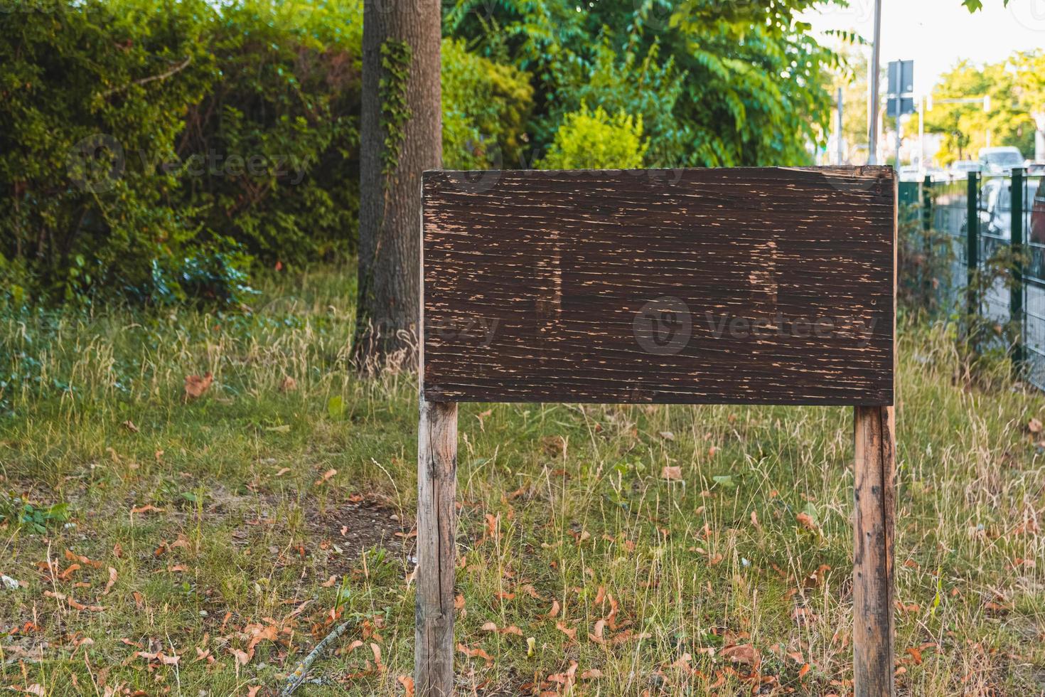 un cartello di legno vuoto in un parco cittadino foto