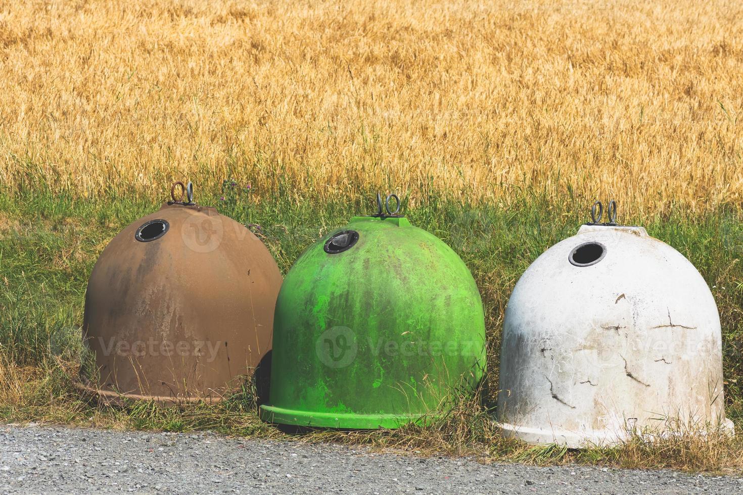 tre contenitori di vetro davanti a un campo foto