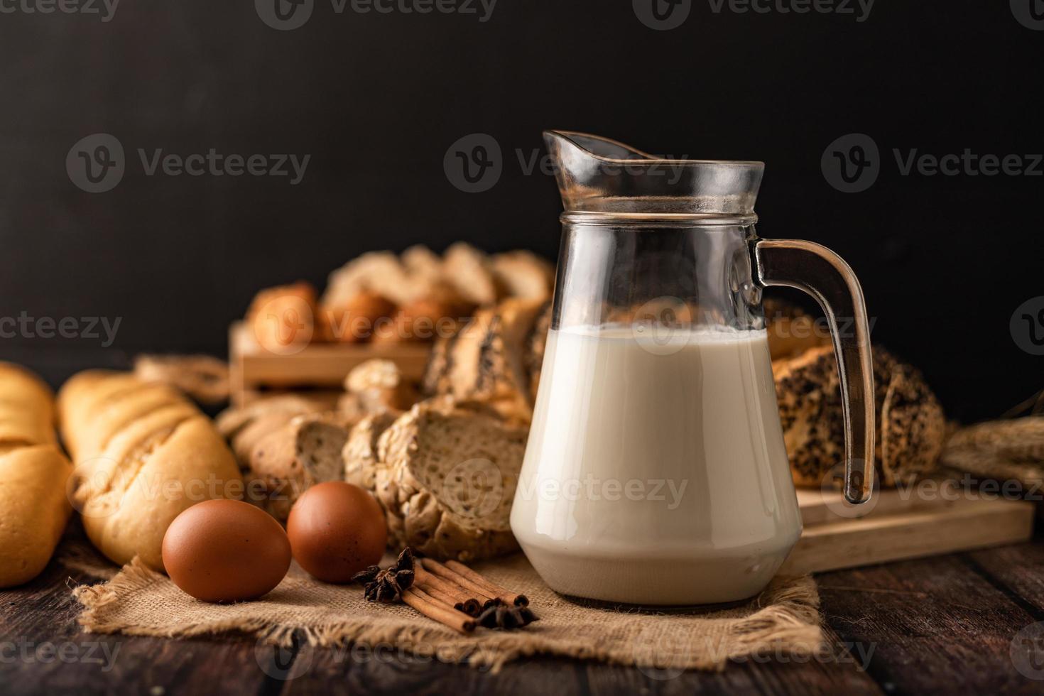 latte in una bottiglia di vetro posta su un tavolo di legno con ingredienti foto