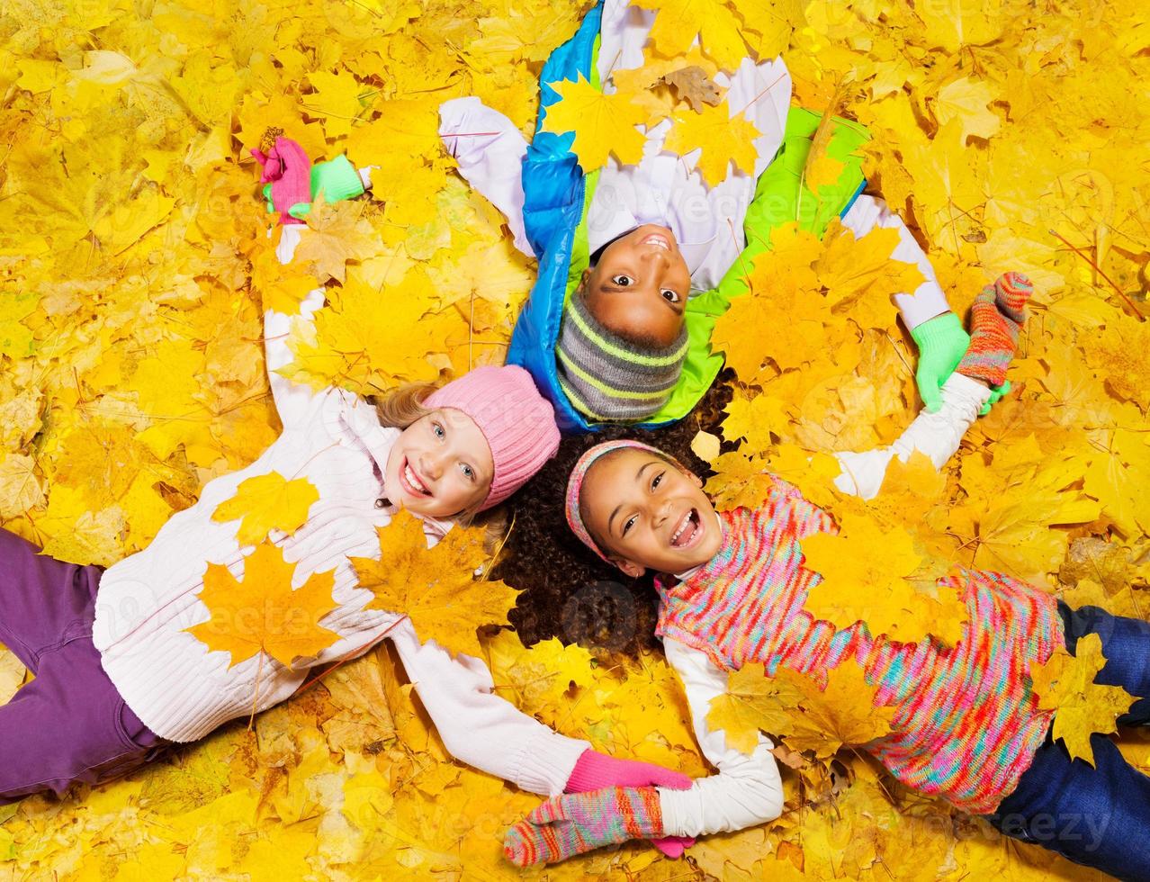 i bambini giocano con foglie di acero autunnali foto