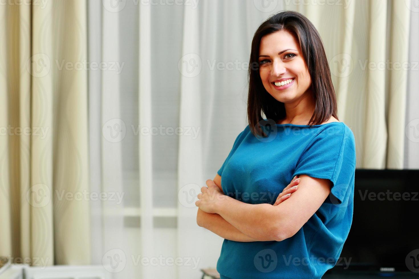 donna sorridente felice in piedi con le braccia conserte foto