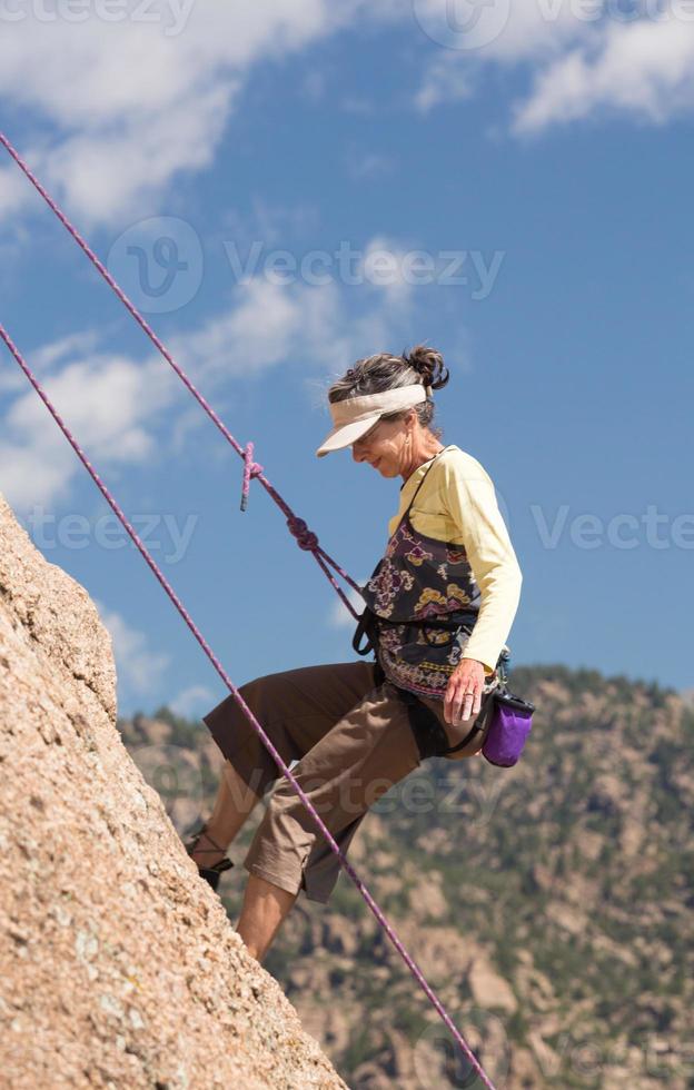 signora senior sulla ripida scalata di roccia in colorado foto