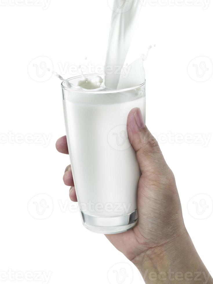 mano con un bicchiere di latte su sfondo bianco foto