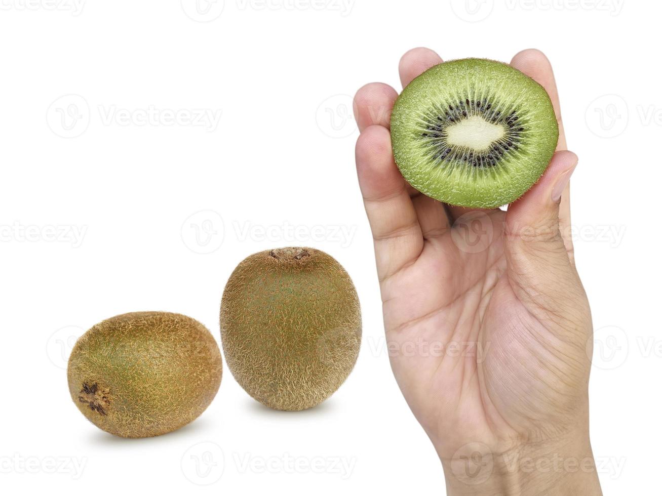 la mano tiene la metà affettata del kiwi isolata su fondo bianco foto