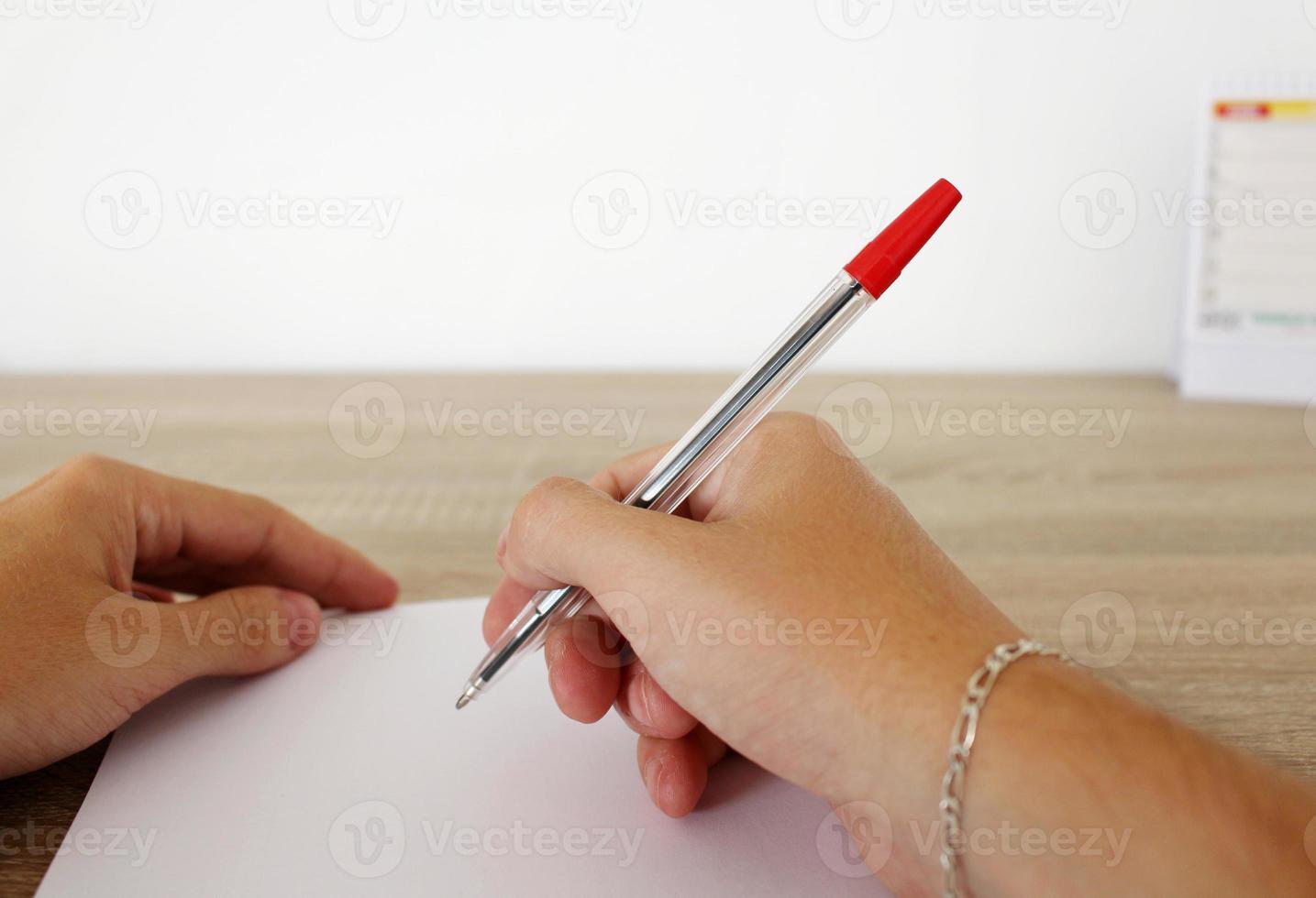l'uomo sta scrivendo sulla carta con la penna foto