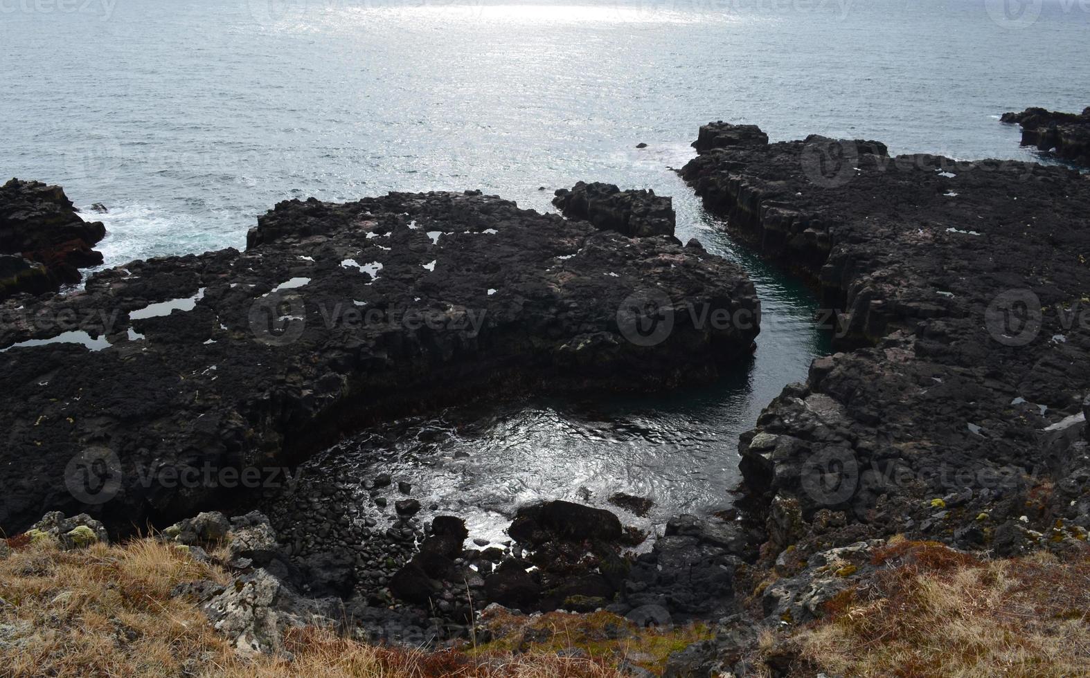 guardando le scogliere del mare di roccia lavica in Islanda foto