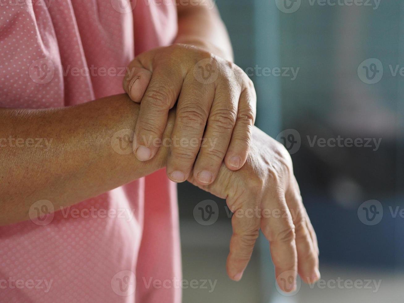 sindrome di Guillan barre, trattamento con coronavirus covid-19 vaccino, donna che si tiene per mano malattia rara il sistema immunitario del corpo attacca i nervi foto