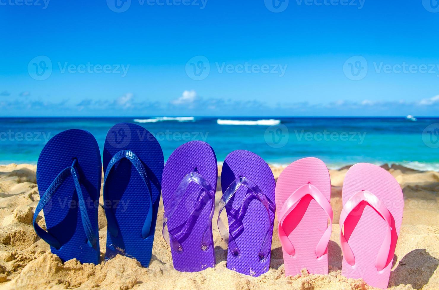 infradito colorate sulla spiaggia di sabbia foto