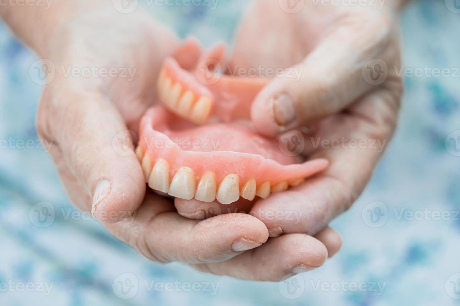 paziente anziana o anziana asiatica che tiene per usare la dentiera nel reparto ospedaliero di cura, concetto medico forte foto