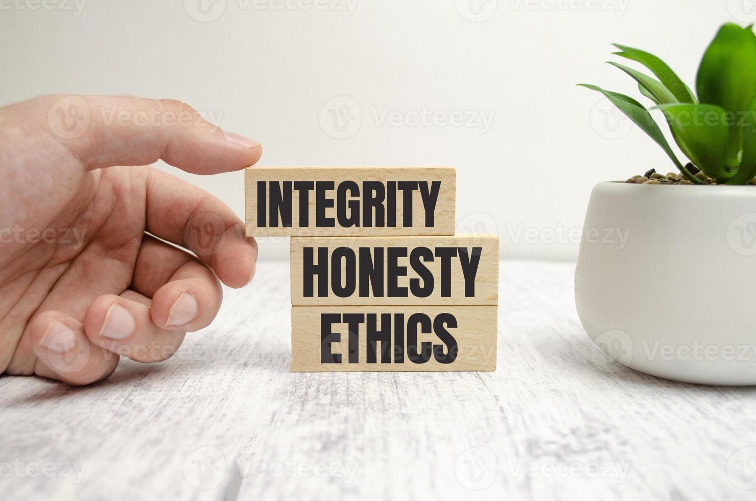 integrità, onestà, etica parole su blocchi di legno e mano foto