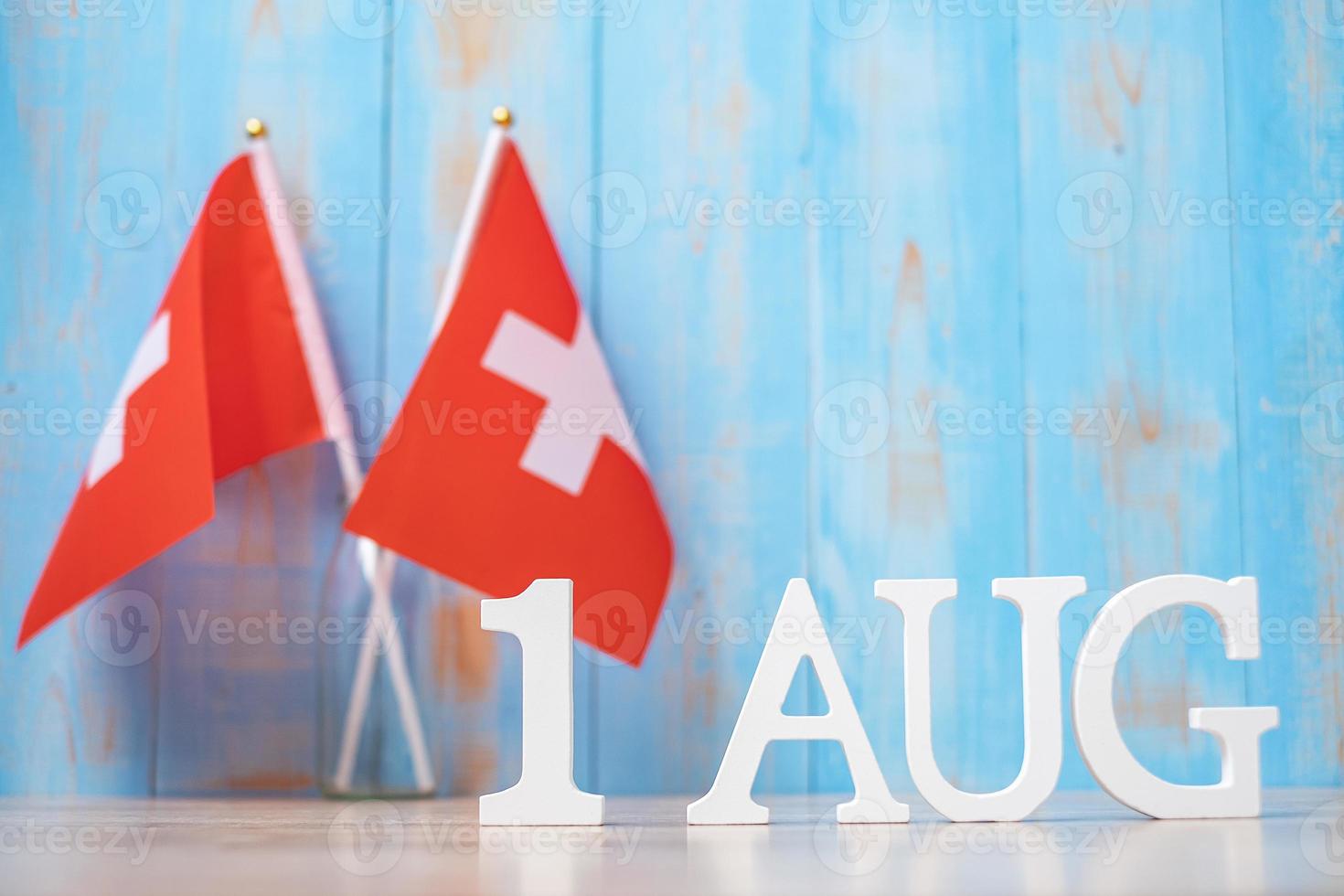 testo in legno del 1° agosto con bandiere svizzere in miniatura. giorno nazionale della svizzera e concetti di celebrazione felice foto