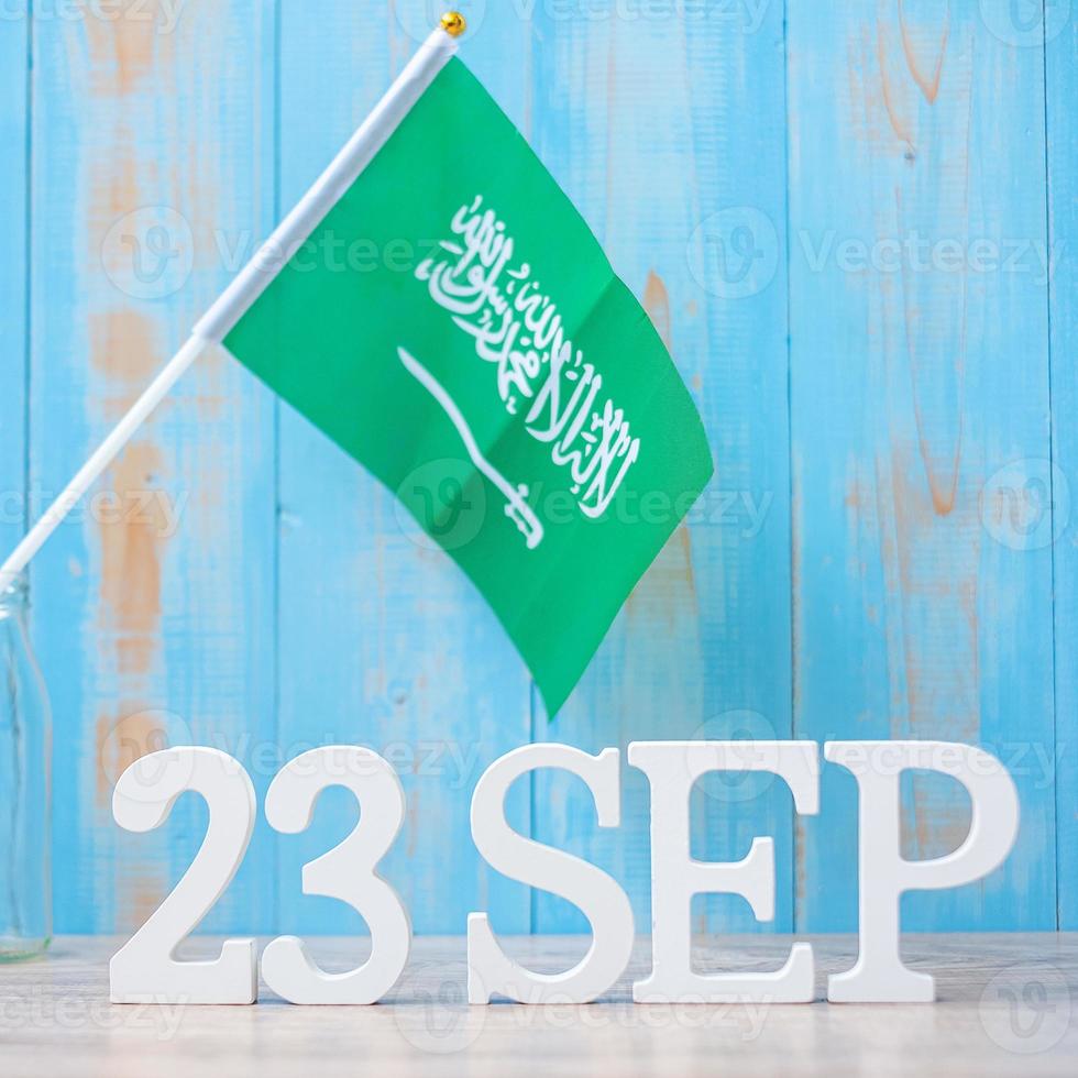 testo in legno del 23 settembre con bandiere dell'arabia saudita. settembre festa nazionale dell'arabia saudita e concetti di celebrazione felice foto