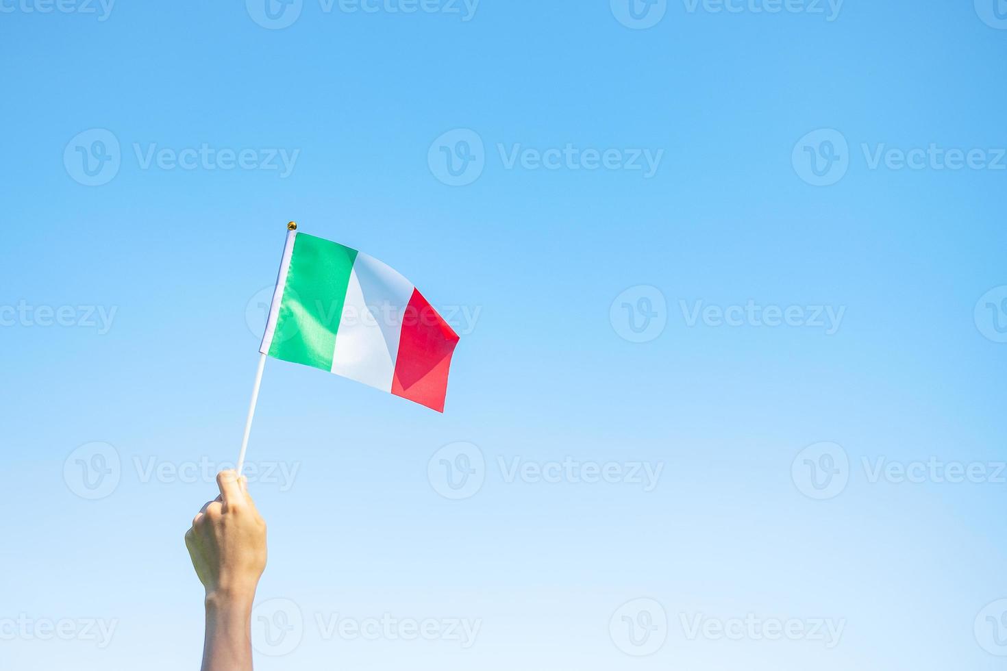 mano che tiene la bandiera dell'italia sullo sfondo della natura. concetti di festa nazionale, festa della repubblica, festa della repubblica e felice celebrazione foto