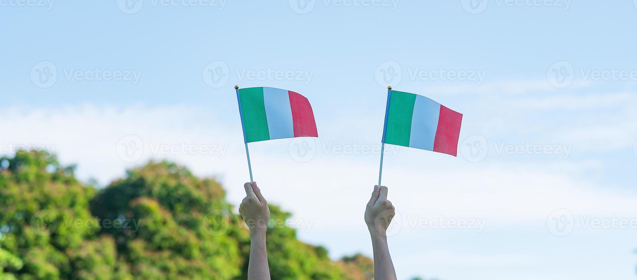 mano che tiene la bandiera dell'italia sullo sfondo della natura. concetti di festa nazionale, festa della repubblica, festa della repubblica e felice celebrazione foto