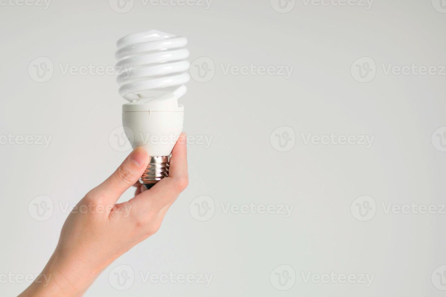 mano che tiene la lampadina fluorescente. foto